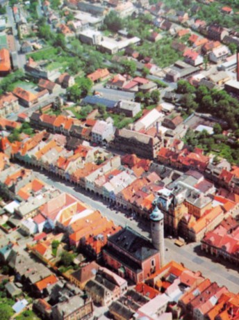 Letecký pohled na na ulicové náměstí s děkanským kostelem s válcovou věží
