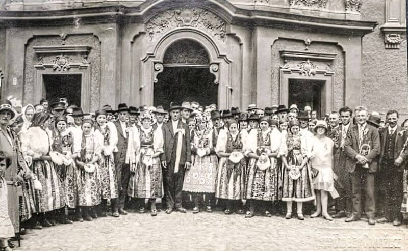 Svatebčané před farním kostelem na náměstí v Domažlicích 
